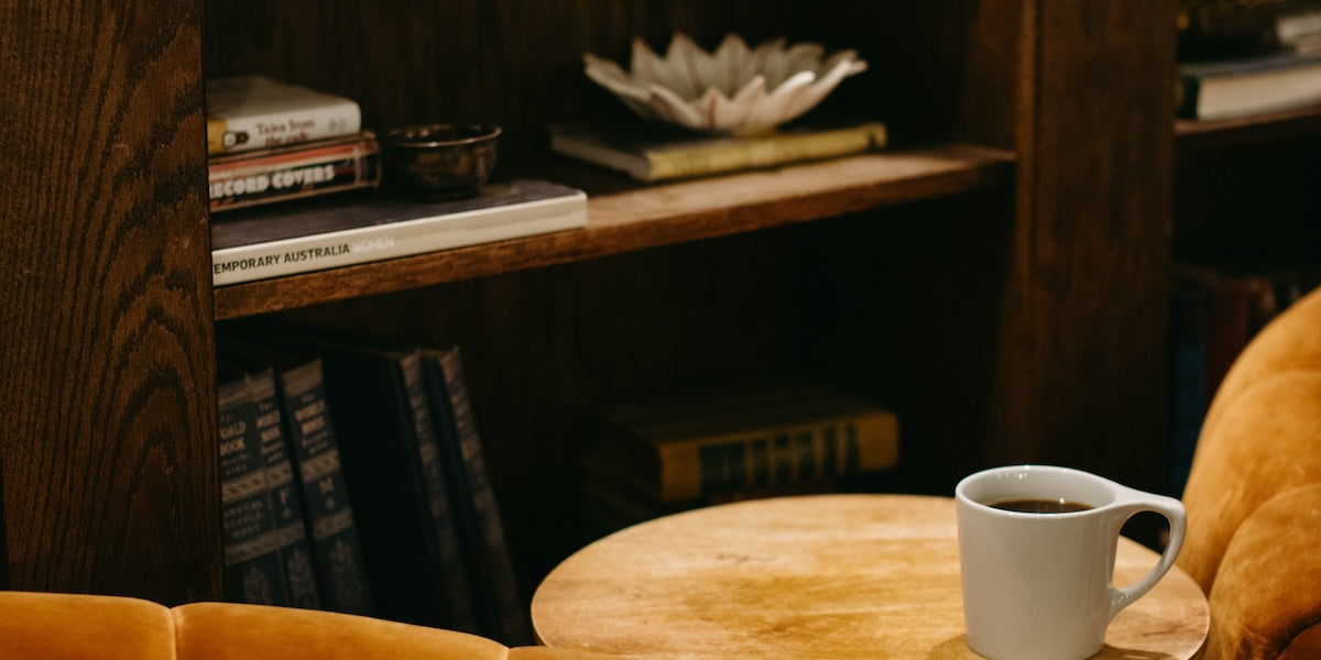velvet circular chairs at cherry coffee shop next to a cup of drip coffee