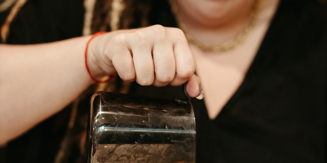 photograph of smiling woman pouring steamed milk into coffee mug