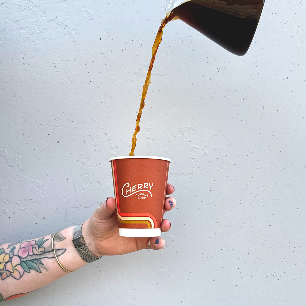 coffee being poured high into a to-go cherry coffee shop