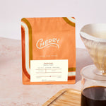 photograph of 'daybreak medium roast' coffee next to a glass cup of coffee