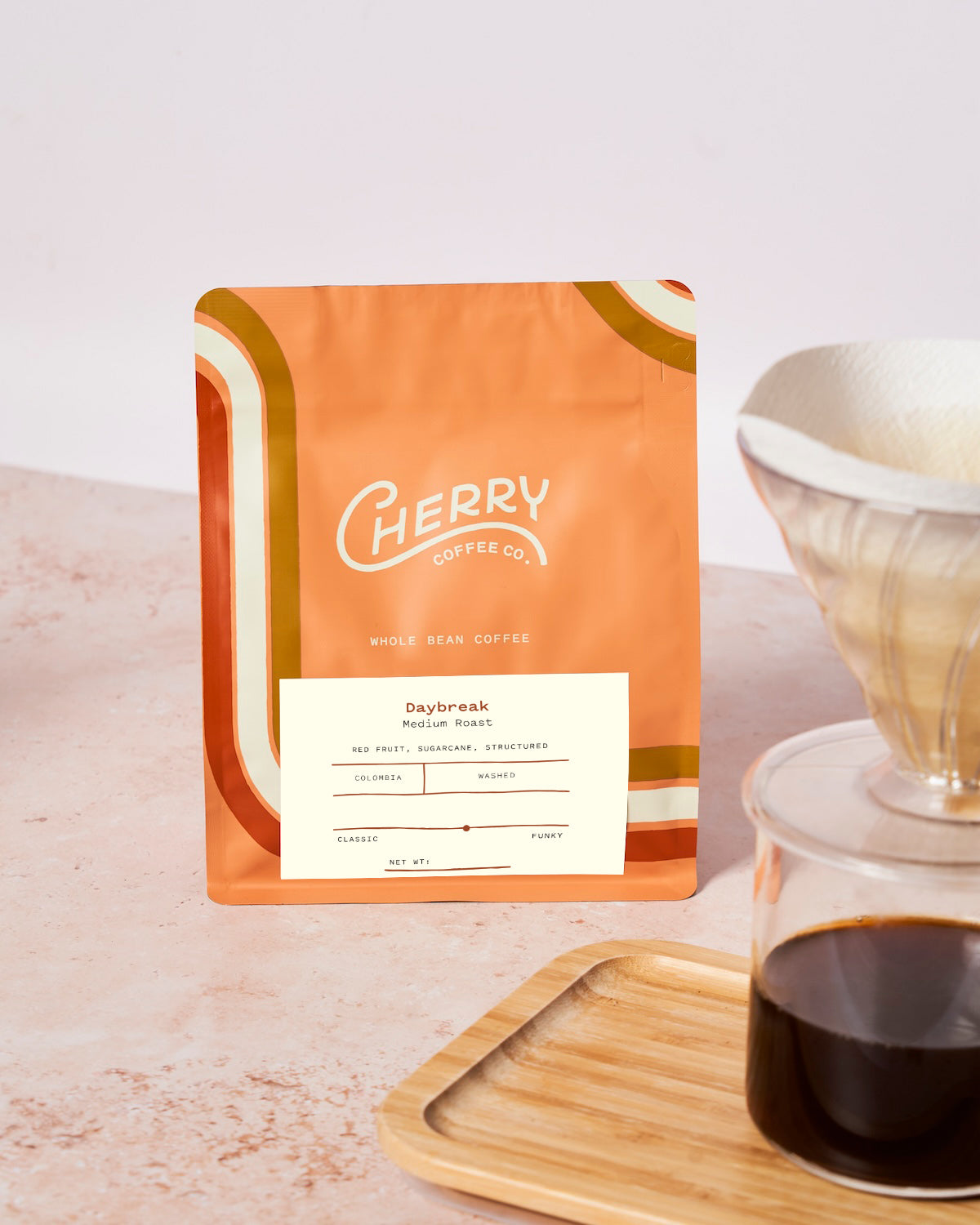 photograph of 'daybreak medium roast' coffee next to a glass cup of coffee