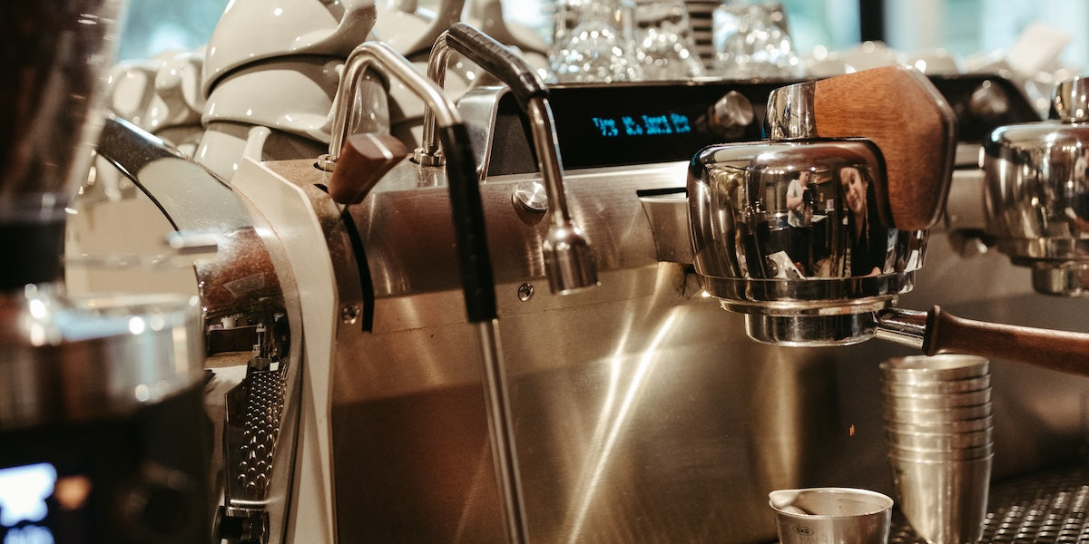 Stainless steel espresso machine on a counter with blurred background